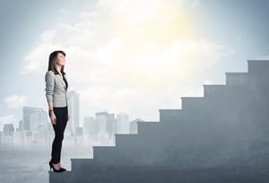 Businesswoman climbing up a concrete staircase concept on city background